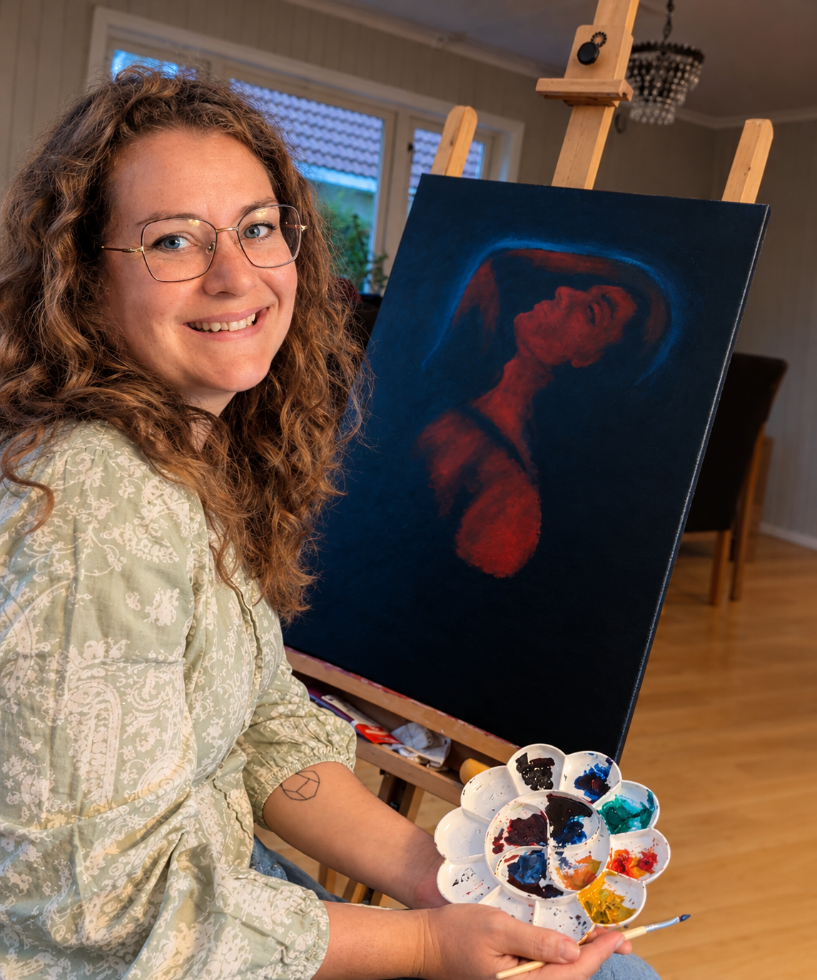 Lisa Wilberg Helmen at her easel with one of her paintings